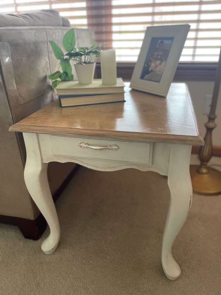 white side table in living room with photo frame and other decor items 